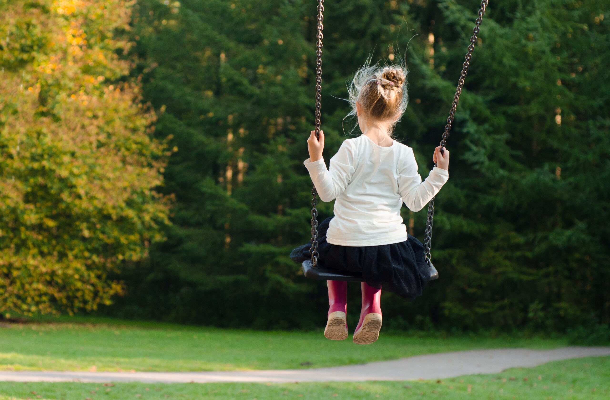 Mädchen auf einer Schaukel im Wald